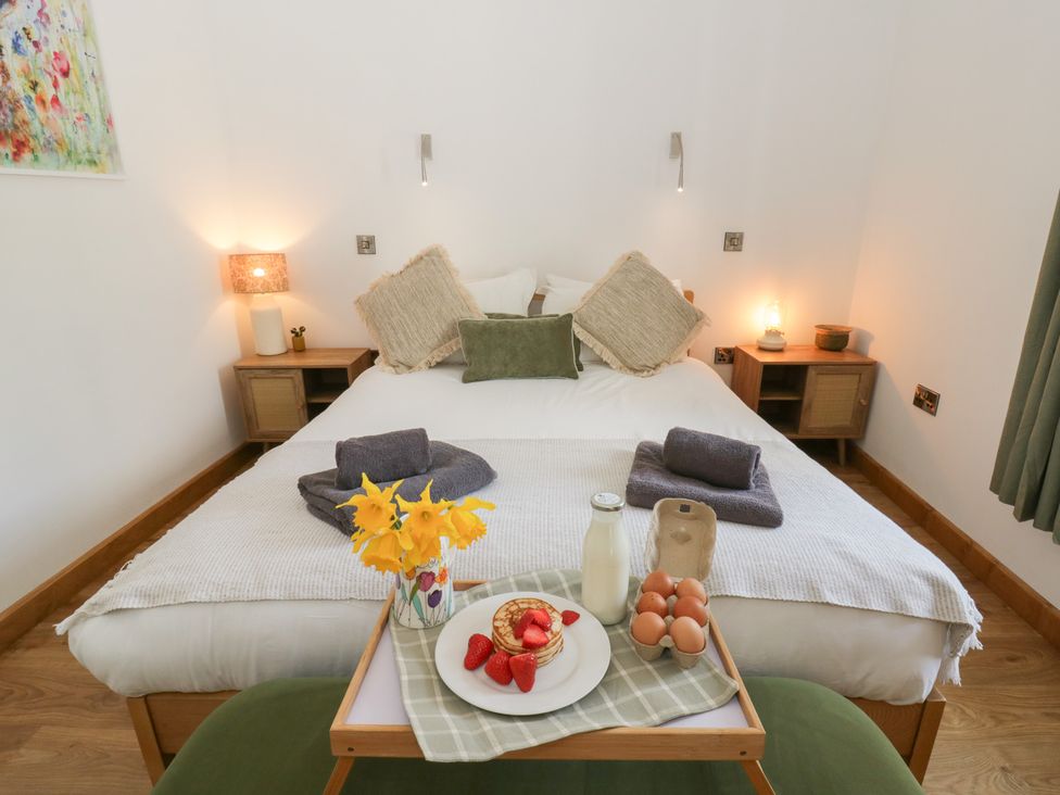 A bedroom with a bed and breakfast tray at Eleri’s Barn Nantmel near Rhayader