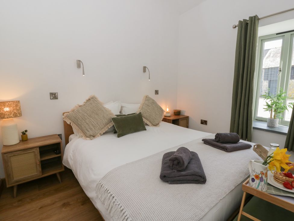 A bedroom with a bed and bedside lamps at Eleri’s Barn Nantmel near Rhayader