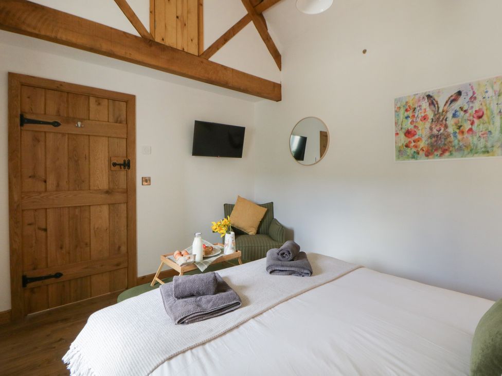 A bedroom with a bed and a door at Eleri’s Barn Nantmel near Rhayader