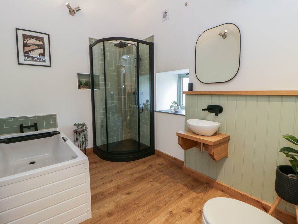 A bathroom with a shower, bathtub, sink, and toilet at Eleri’s Barn Nantmel near Rhayader