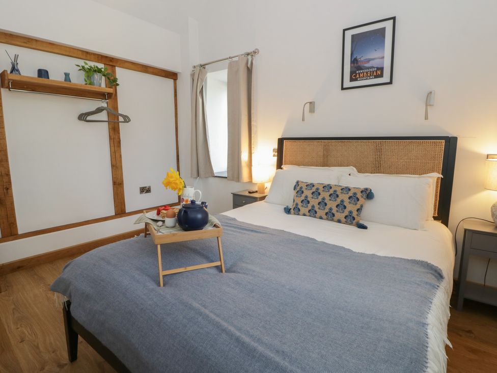 A bedroom with a bed and decorative items at Eleri’s Barn Nantmel near Rhayader