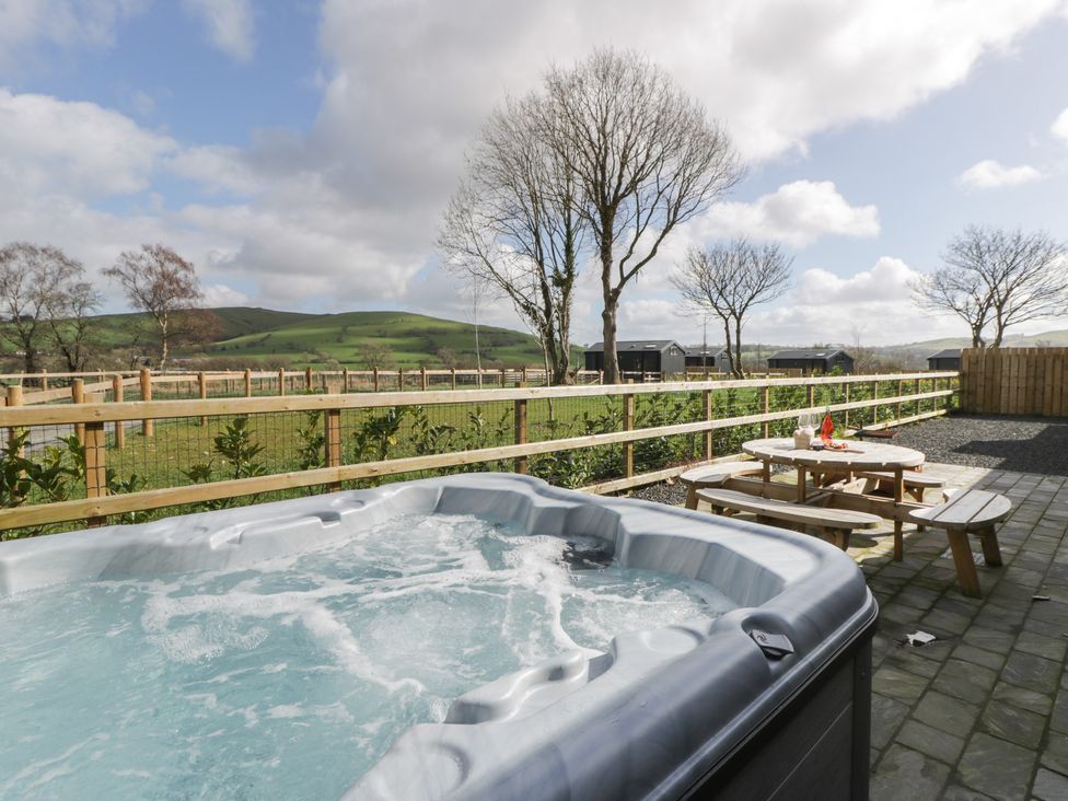 An outdoor area with a hot tub and picnic table at Eleri’s Barn Nantmel near Rhayader