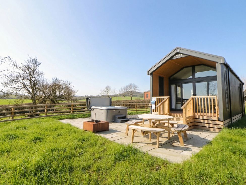 An outdoor area with a hot tub and seating at Daverneithon 1 Near Llandrindod Wells