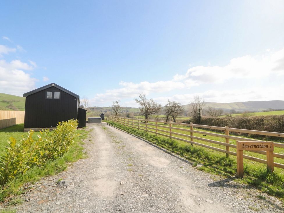 A black cabin with a gravel driveway at Daverneithon 1 near Llandrindod Wells