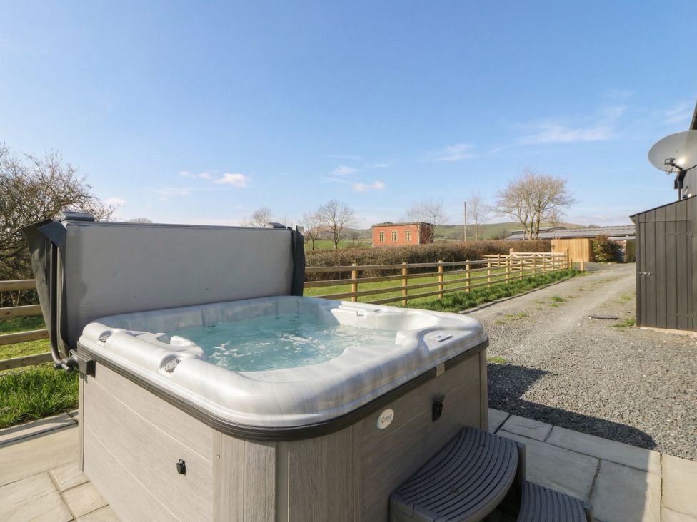 A hot tub with steps and a gravel path at Daverneithon 1 near Llandrindod Wells