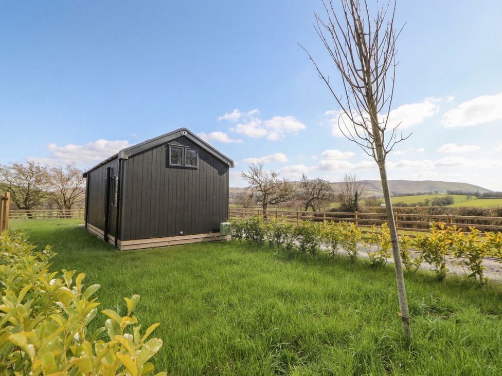 A cabin surrounded by grass and trees at Daverneithon 1 near Llandrindod Wells