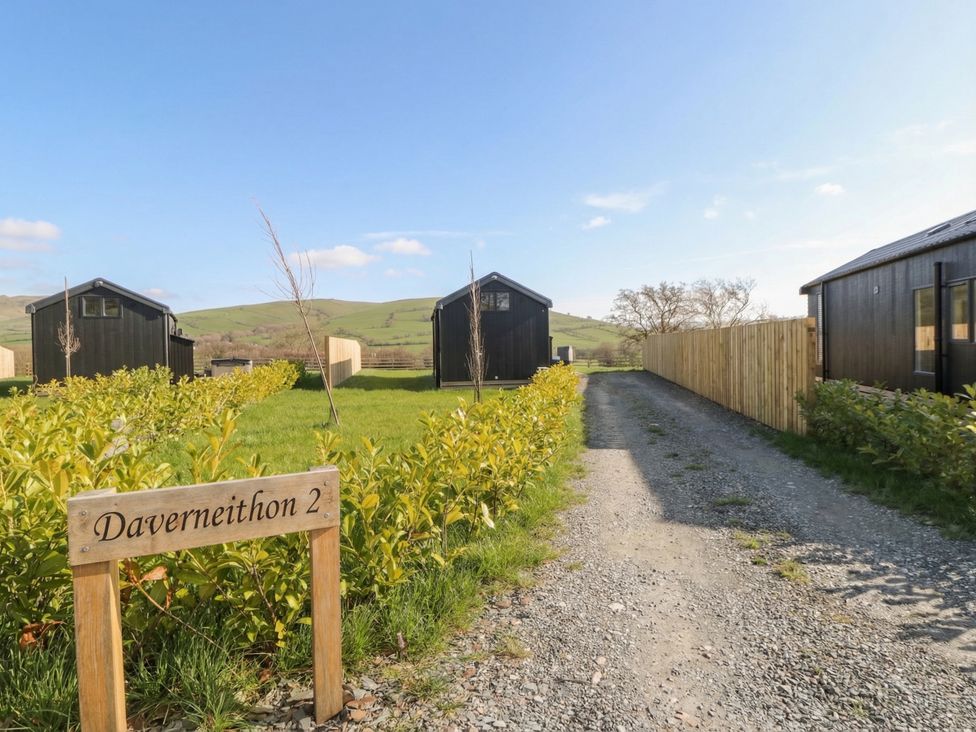 An outdoor area with cabins and a gravel path at Daverneithon 2 near Llandrindod Wells