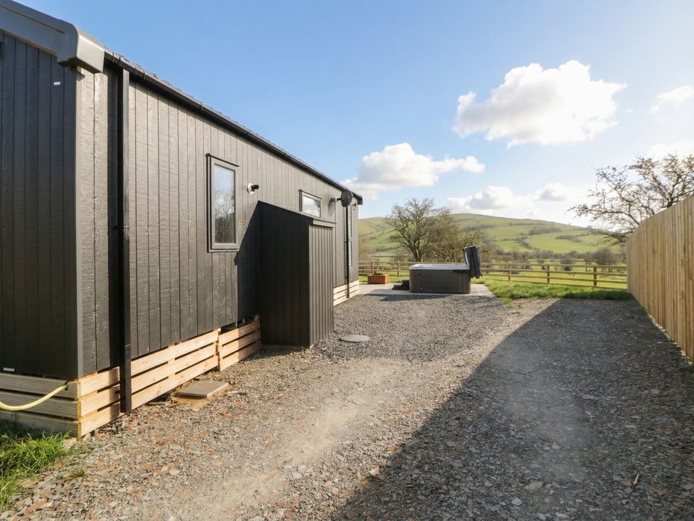 An outdoor area with a cabin and hot tub at Daverneithon 2 near Llandrindod Wells