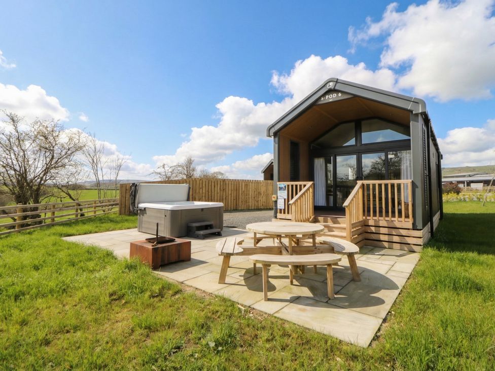An outdoor area with a hot tub and seating at Daverneithon 2 near Llandrindod Wells