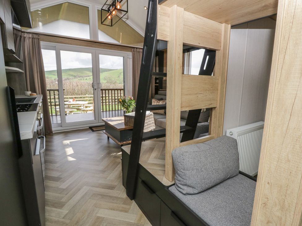 A living room with a bunk bed and a view of hills at Daverneithon 2 near Llandrindod Wells