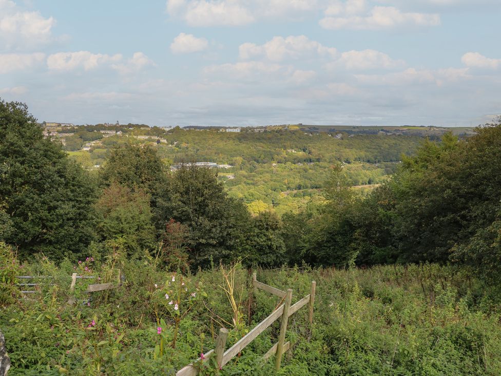 A view of hills and trees from a garden at 11 Hollin Well Cottage in Sowerby Bridge