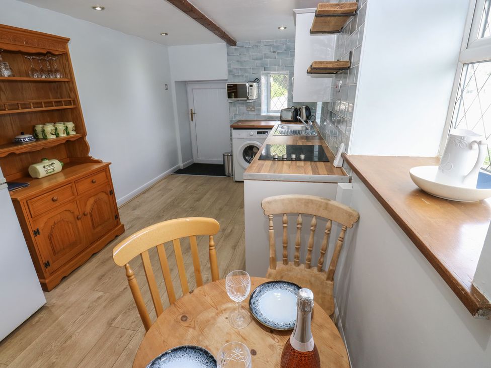 A kitchen with a dining table and chairs at 11 Hollin Well Cottage in Sowerby Bridge