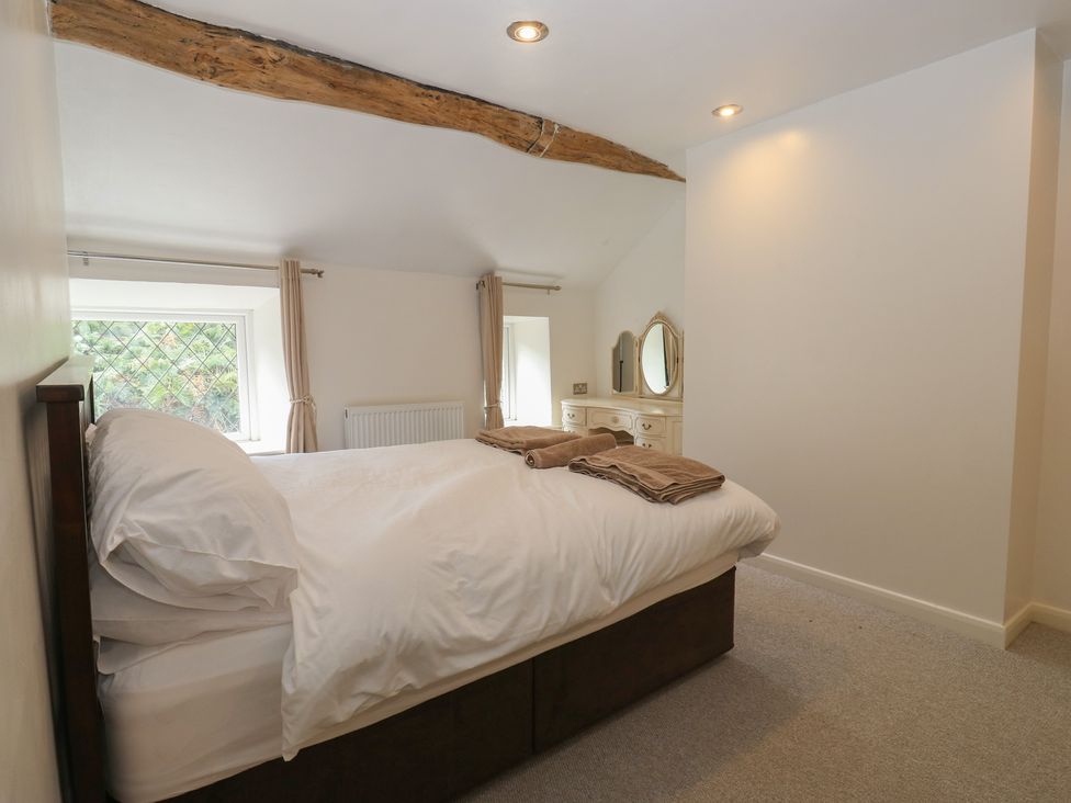 A bedroom with a bed and dresser at 11 Hollin Well Cottage, Sowerby Bridge