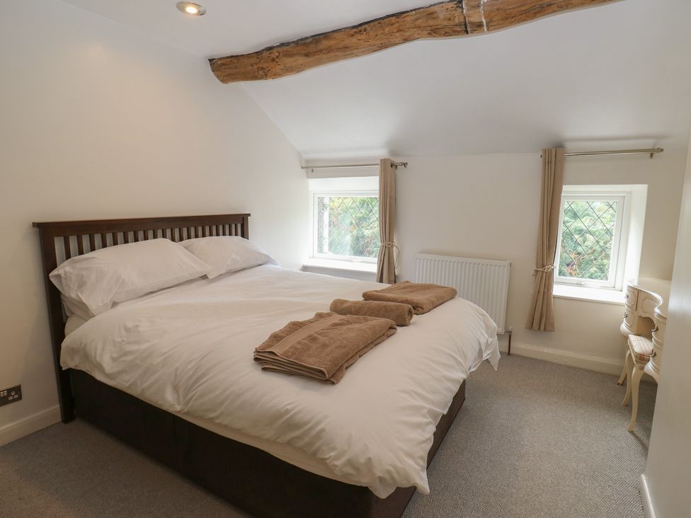 A bedroom with a bed and towels at 11 Hollin Well Cottage Sowerby Bridge