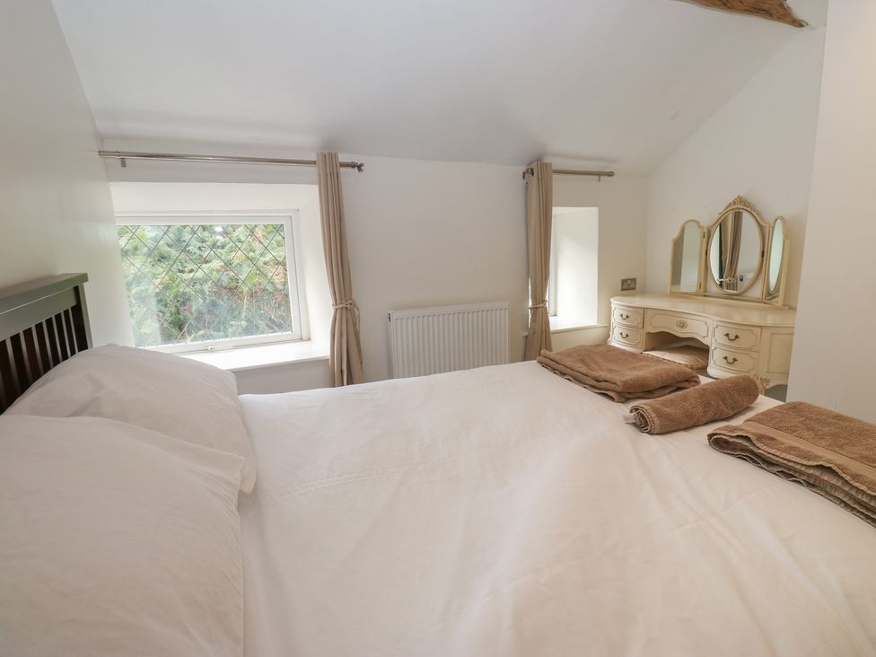 A bedroom with a bed and dressing table at 11 Hollin Well Cottage Sowerby Bridge