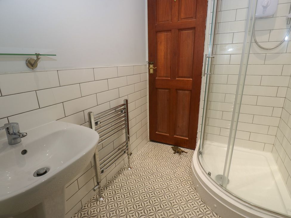 A bathroom with a shower and wash basin at 11 Hollin Well Cottage Sowerby Bridge