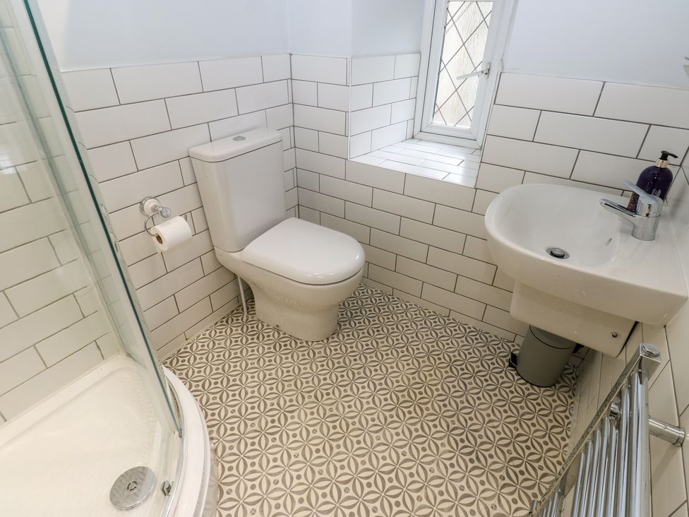 A bathroom with a toilet, sink, and shower at 11 Hollin Well Cottage in Sowerby Bridge