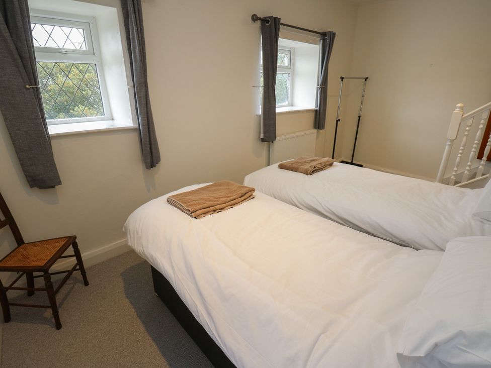 A bedroom with two single beds and towels at 11 Hollin Well Cottage Sowerby Bridge