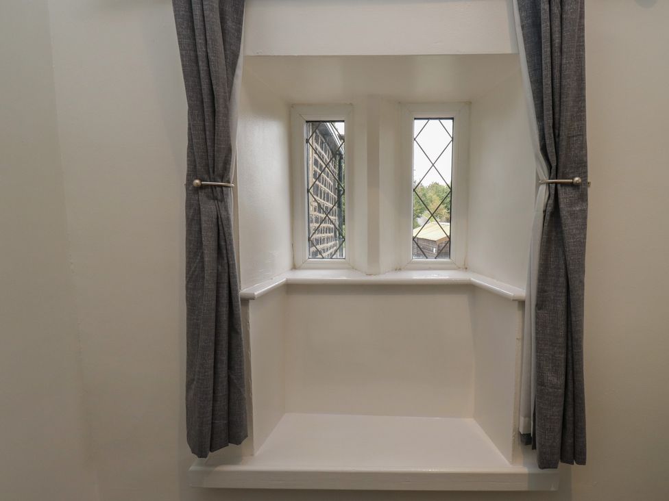 A nook with windows and grey curtains at 11 Hollin Well Cottage Sowerby Bridge