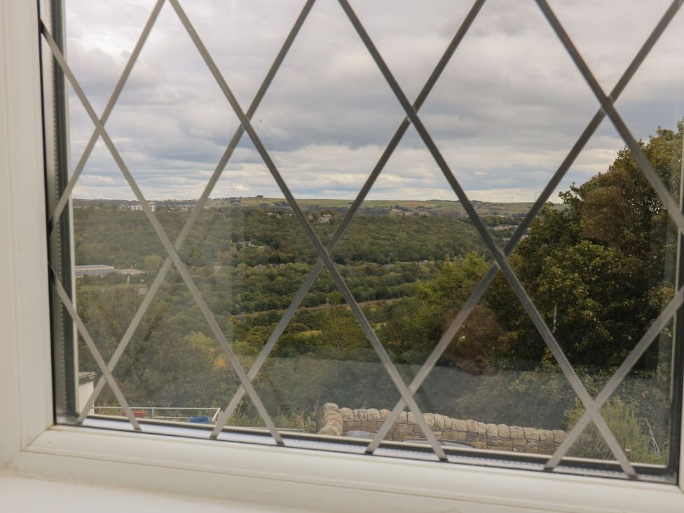 A view from a window showing hills and trees at 11 Hollin Well Cottage Sowerby Bridge
