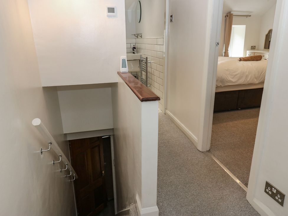 A hallway with a staircase and door at 11 Hollin Well Cottage Sowerby Bridge