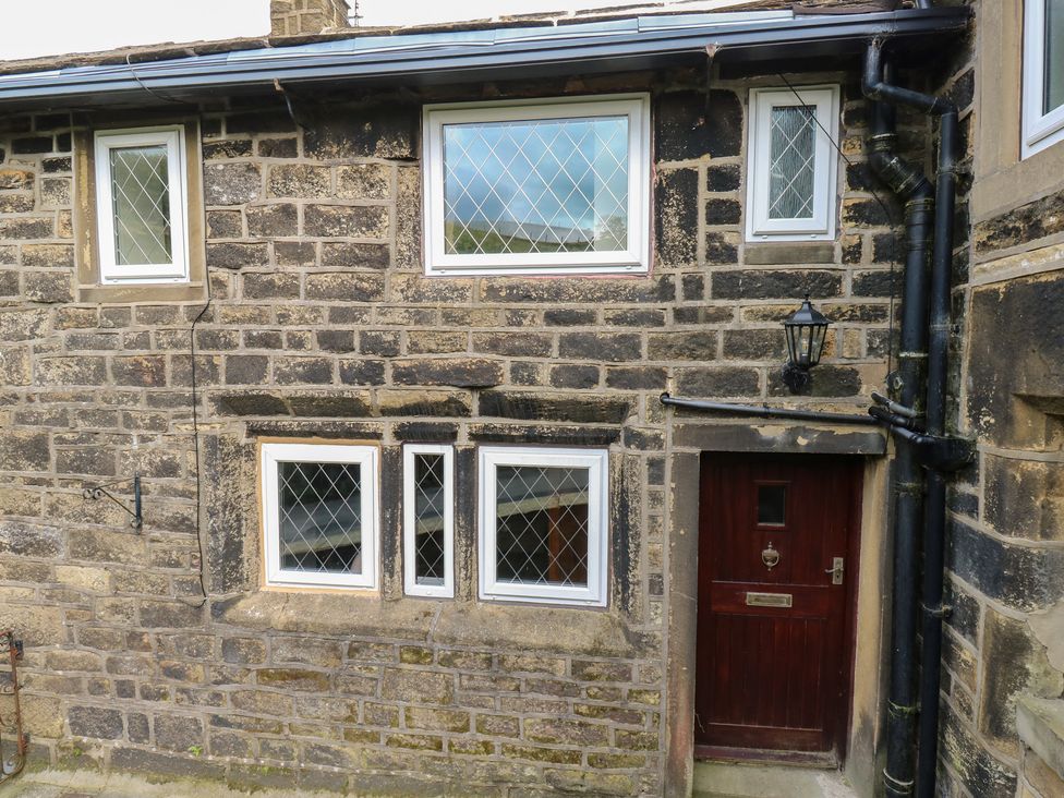 An exterior view showing windows and a door at 11 Hollin Well Cottage Sowerby Bridge