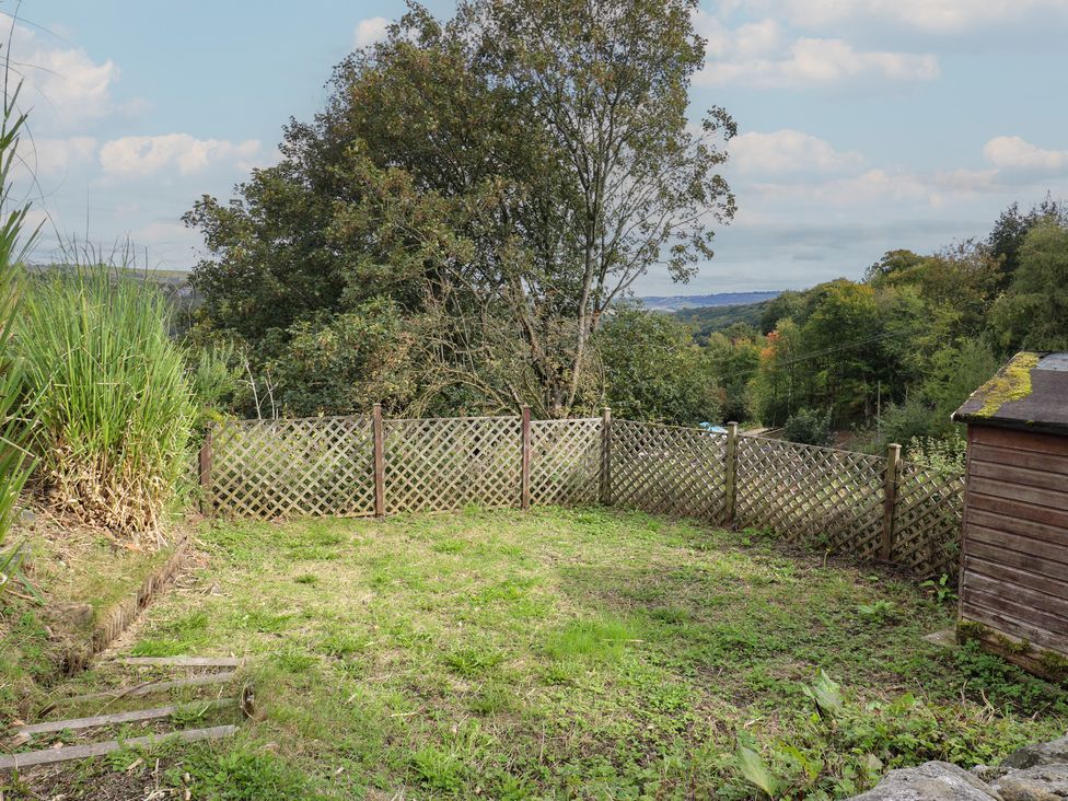 A garden area with a fence and shed at 11 Hollin Well Cottage Sowerby Bridge