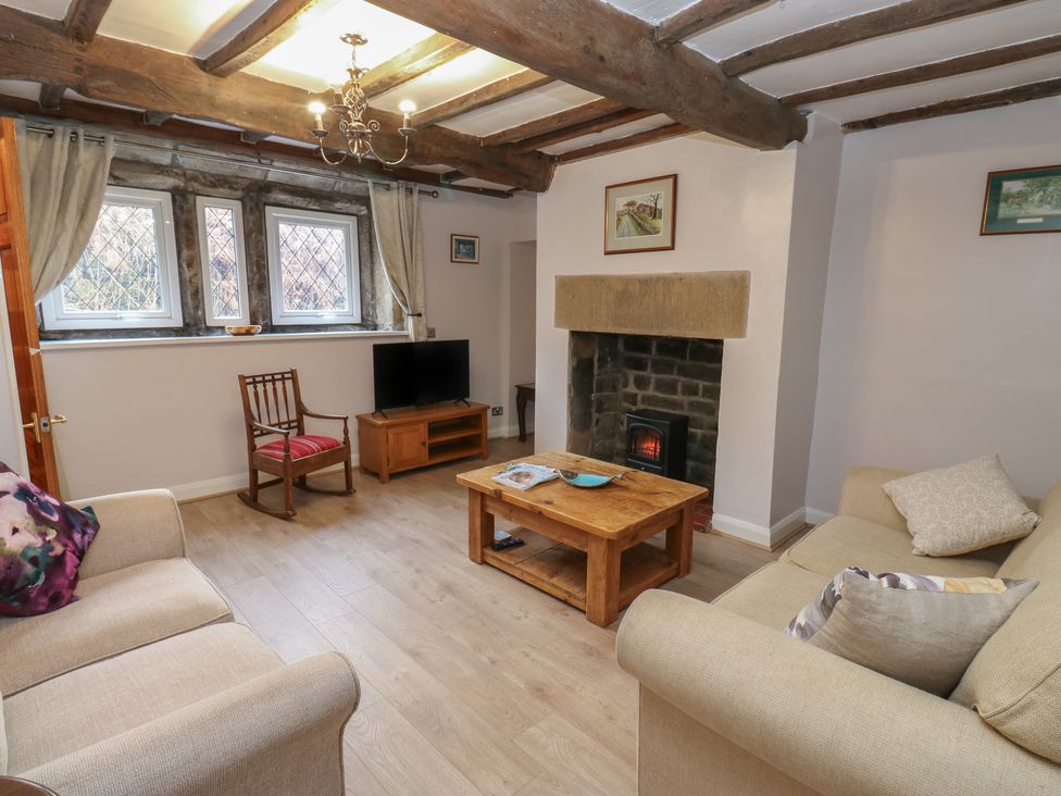 A living room with a sofa and fireplace at 11 Hollin Well Cottage in Sowerby Bridge