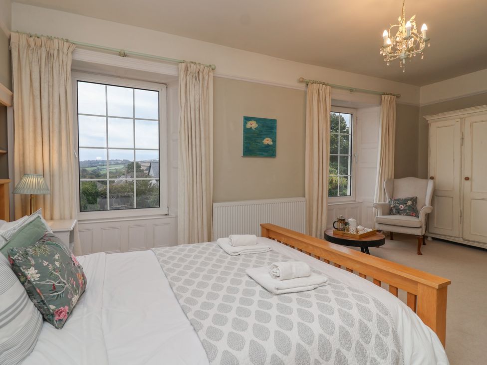 A bedroom with a bed and windows at The Old Manor House in Lifton