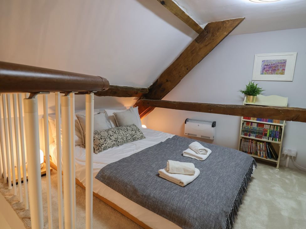 A bedroom with a bed and shelves of books at The Old Manor House in Lifton