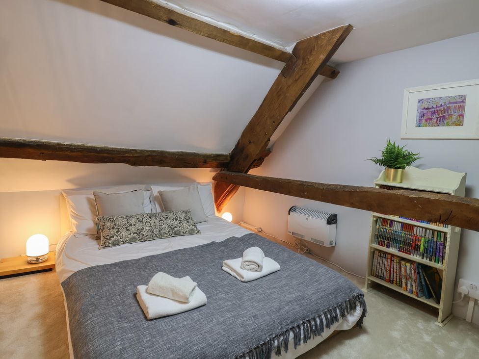 A bedroom with a bed and shelves of books at The Old Manor House in Lifton
