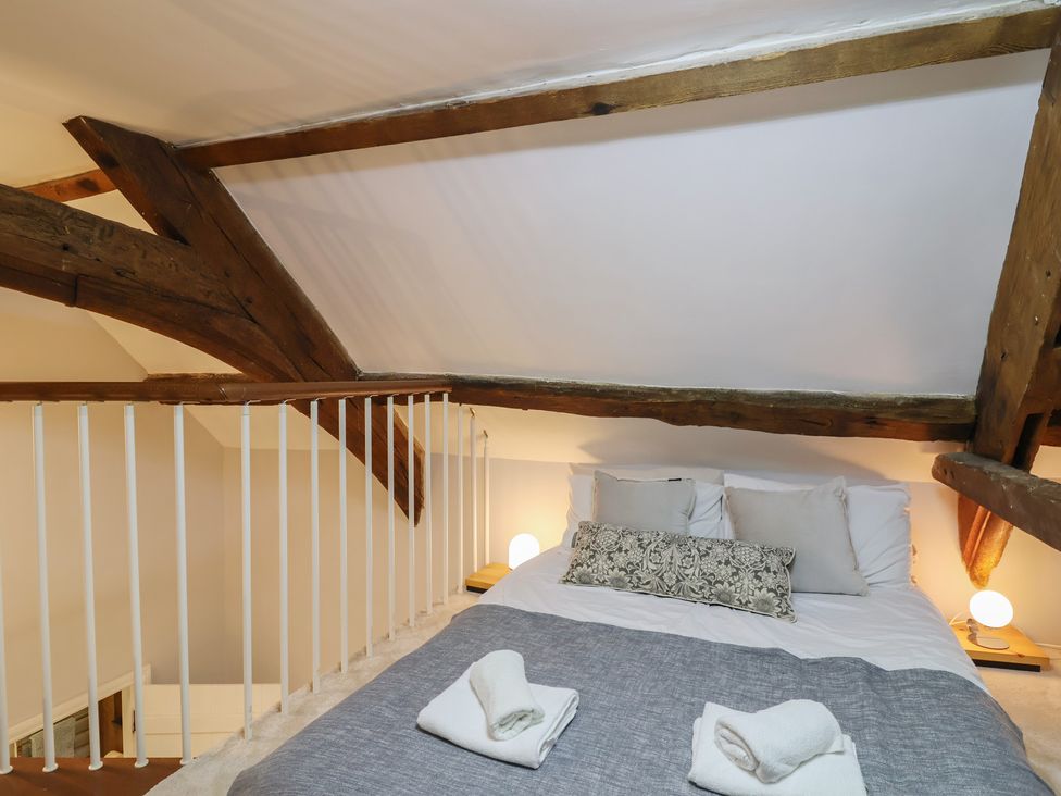 A bedroom with a bed and wooden beams at The Old Manor House in Lifton