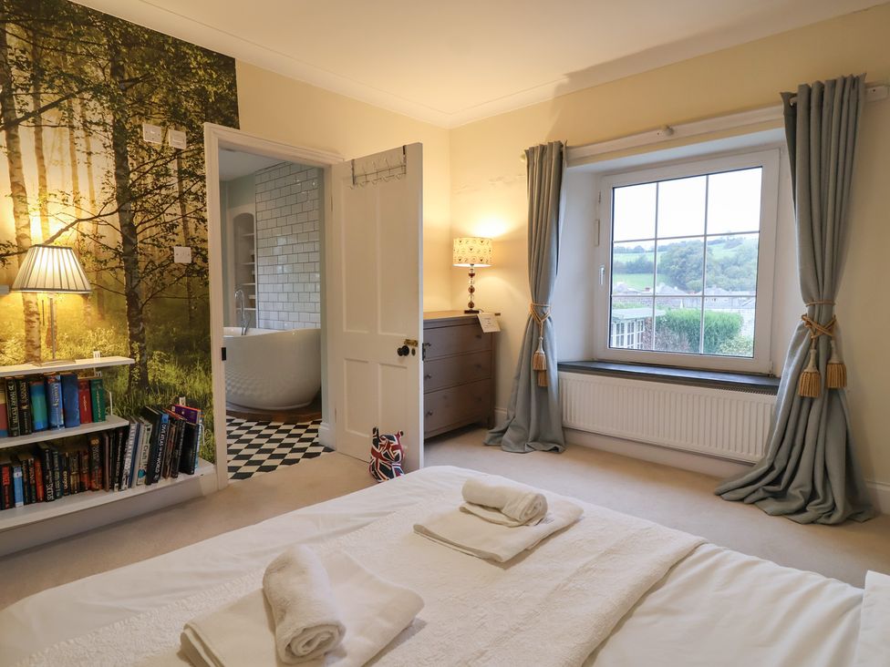 A bedroom with a bed and an adjoining bathroom at The Old Manor House in Lifton