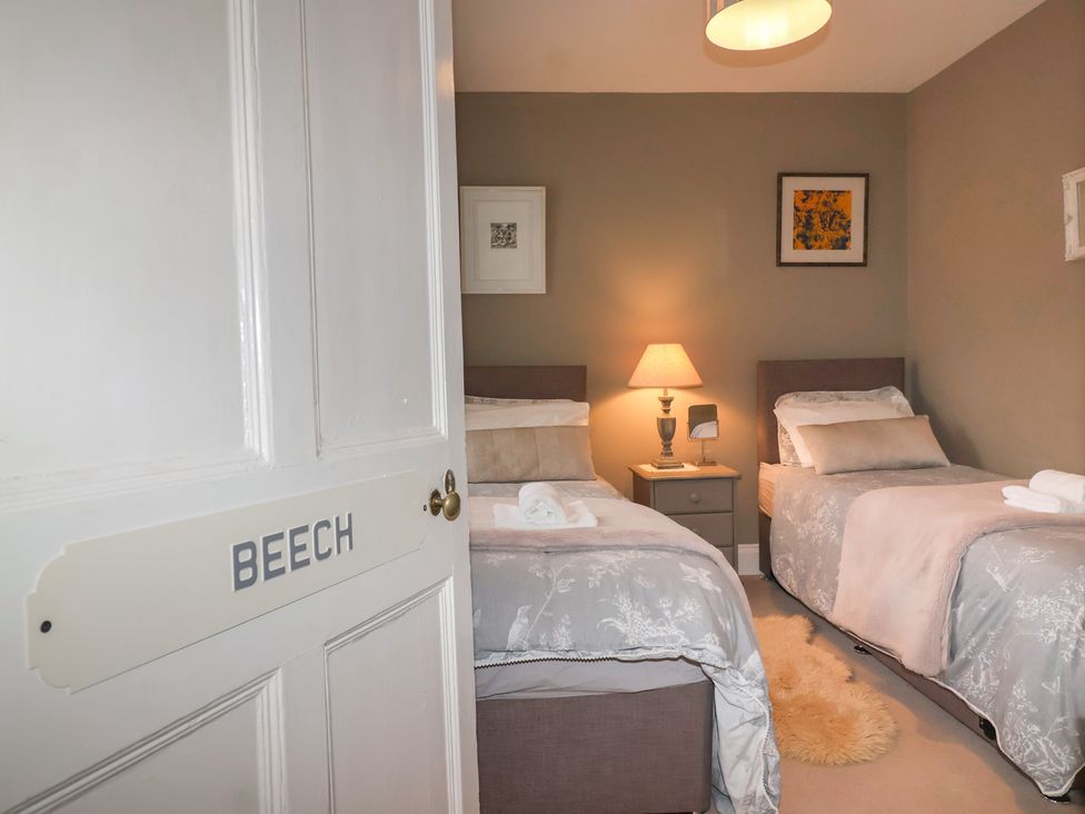 A bedroom with two beds and a nightstand at The Old Manor House in Lifton