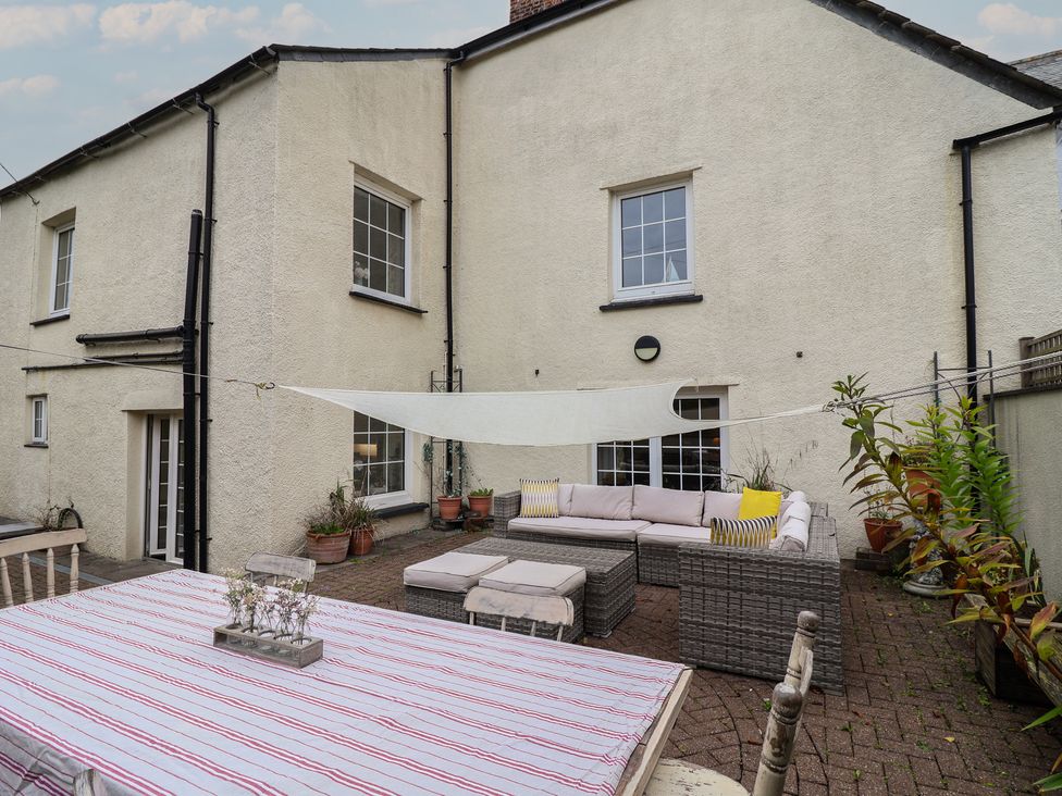 An outdoor seating area with a table and chairs at The Old Manor House in Lifton