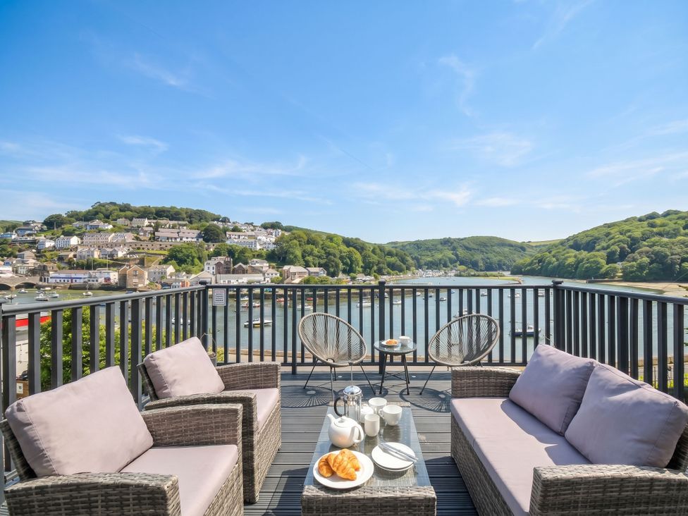 An outdoor seating area with a table and views of water and hills at Overdale