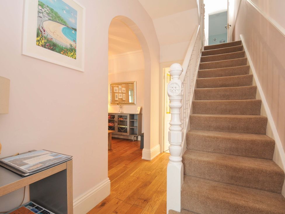 A hallway with a staircase and a console table at Overdale