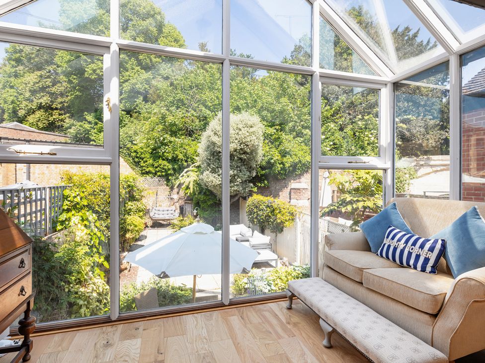 A conservatory with a view of a garden at Castle View in Windsor, Berkshire