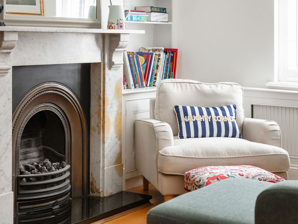 A living room with an armchair and fireplace at Castle View in Windsor, Berkshire