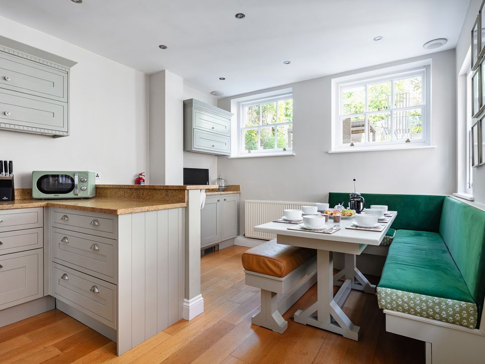 A kitchen with a dining table and bench seating at Castle View in Windsor, Berkshire