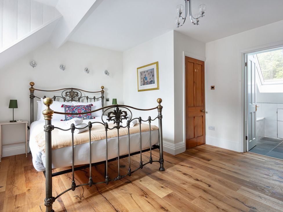 A bedroom with a bed and wooden flooring at Castle View in Windsor, Berkshire