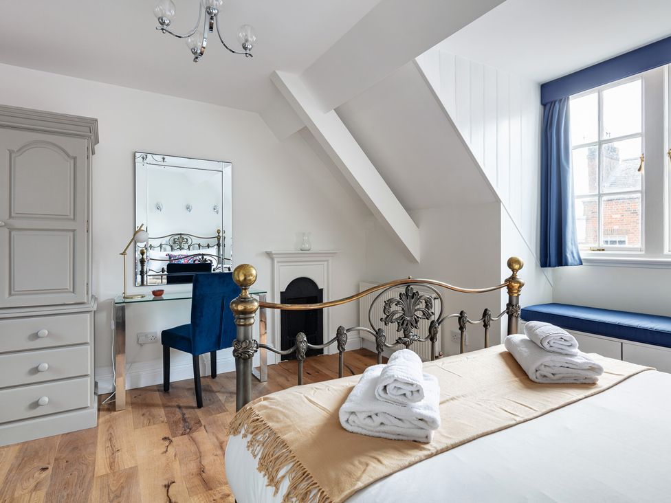 A bedroom with a bed and a mirror at Castle View in Windsor, Berkshire
