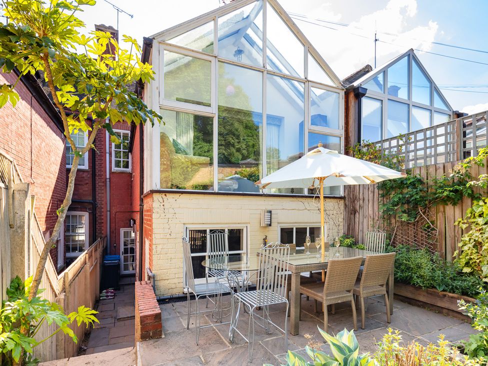A garden with a table and chairs under an umbrella at Castle View, Windsor, Berkshire