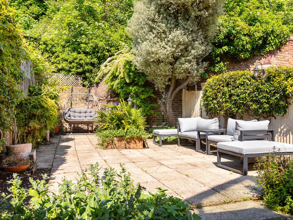 A garden with sun loungers and a swing chair at Castle View, Windsor, Berkshire