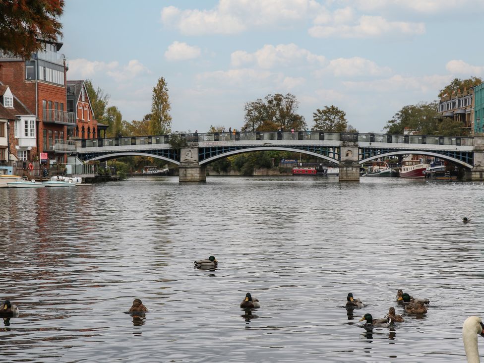 A bridge over water with ducks and boats in front at Castle View in Windsor, Berkshire