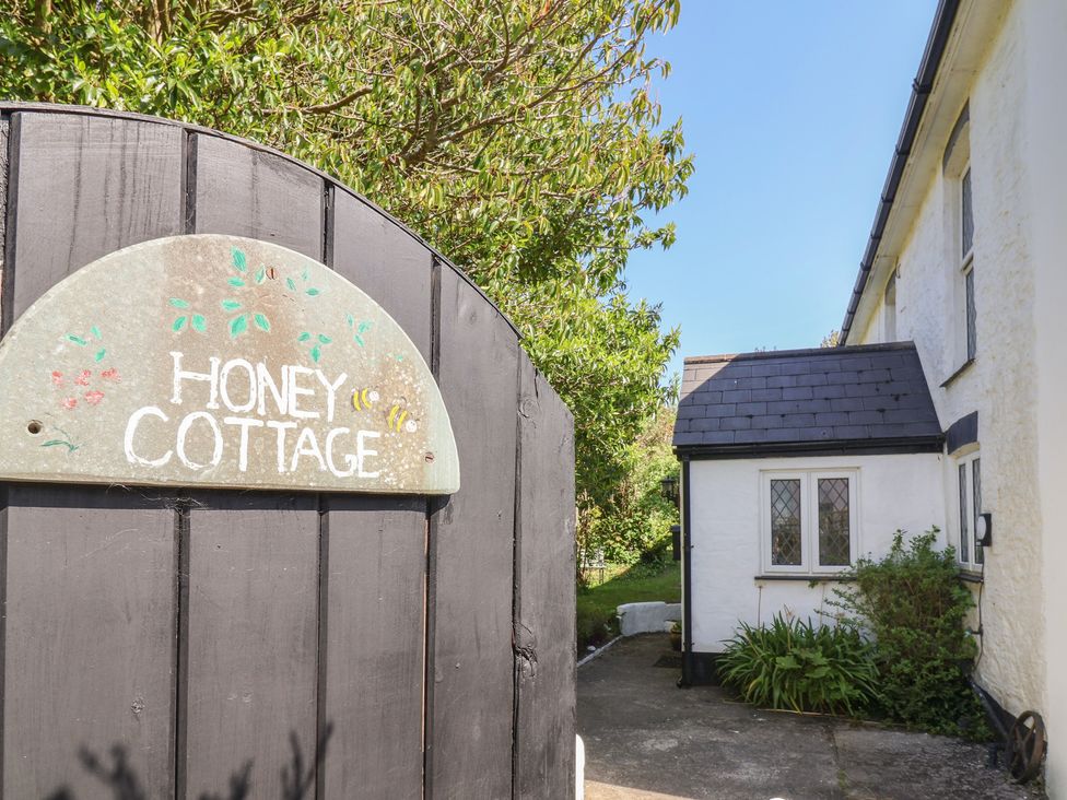 A gate and cottage with a sign at Honey Cottage in Ilfracombe