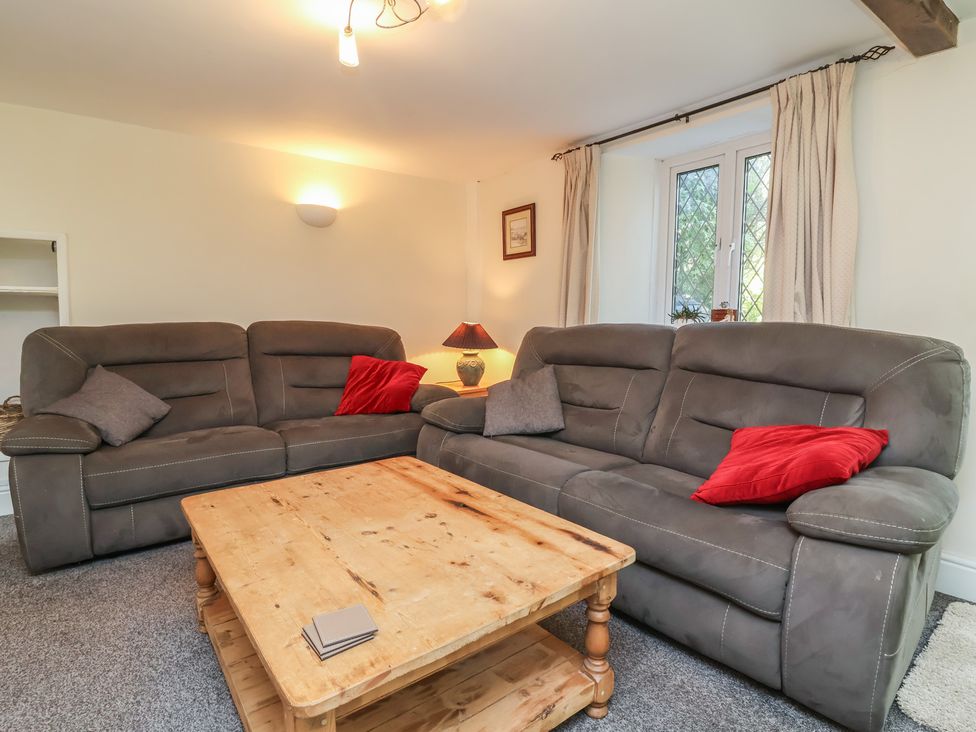 A living room with sofas and a coffee table at Honey Cottage Ilfracombe