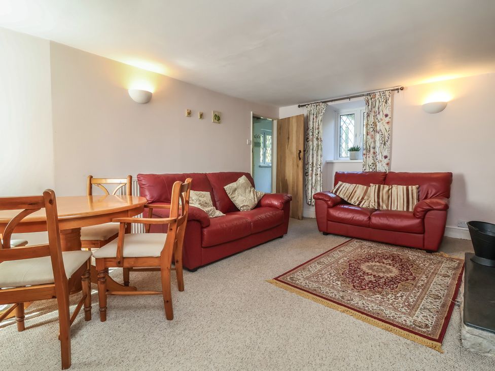 A living room with a dining table and chairs at Honey Cottage in Ilfracombe