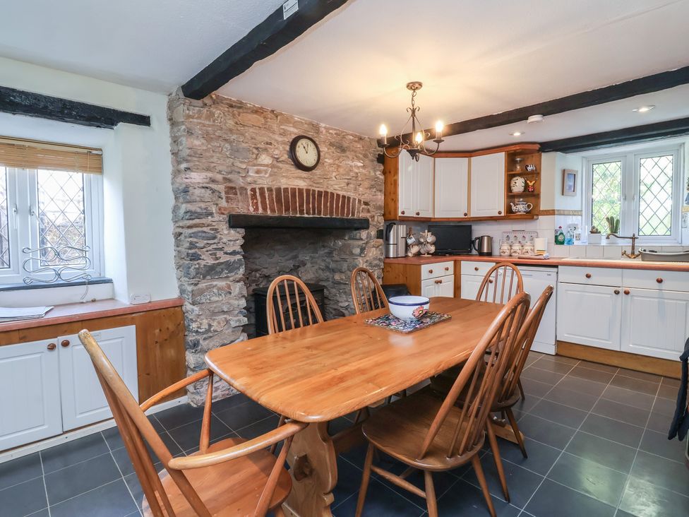 A kitchen with a dining table and chairs at Honey Cottage Ilfracombe