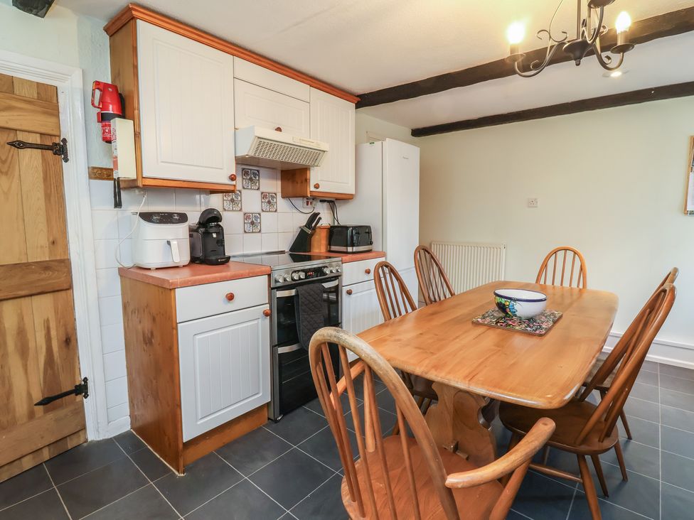 A kitchen with a table and chairs at Honey Cottage in Ilfracombe